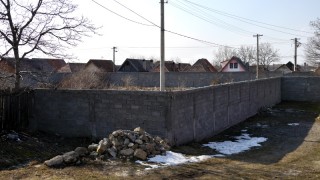 Die mehr als zwei Meter hohe Betonmauer trennt in Tărlungeni die Roma-Siedlung (hinten im Bild) vom Rest der Gemeinde. (Foto: Steffi Unsleber)